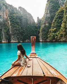 a woman sitting on top of a wooden boat