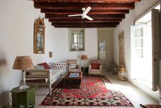 a living room filled with furniture and a ceiling fan mounted to the side of it