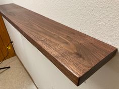 a wooden shelf mounted to the side of a wall