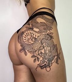 a woman with a tattoo on her thigh showing the back side of her body and an image of a dragon