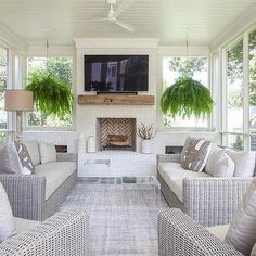 a living room filled with furniture and a flat screen tv mounted on the wall above a fire place