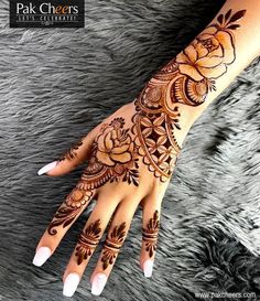 a woman's hand with henna tattoos on it