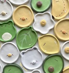 many different colored plates with faces and eyes are arranged in the shape of teddy bears