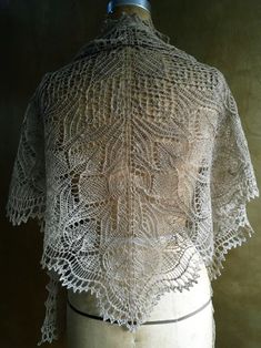 a mannequin wearing a white lacy top with an openwork design on it