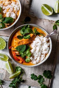 two bowls filled with food and garnished with cilantro, limes, and rice