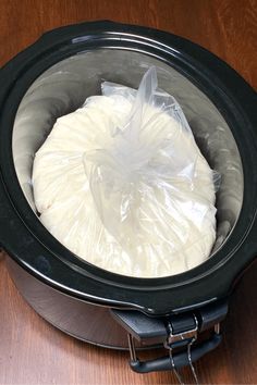 a crock pot filled with food sitting on top of a wooden table