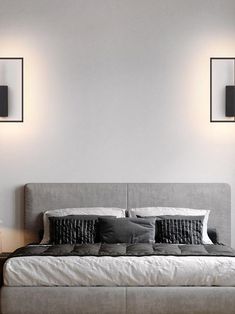 a large bed sitting under two wall lights