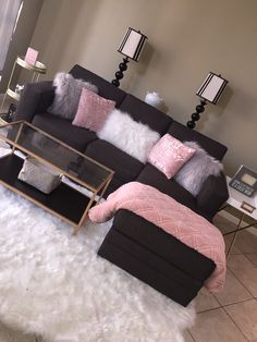 a black and pink couch sitting on top of a white fluffy rug in a living room