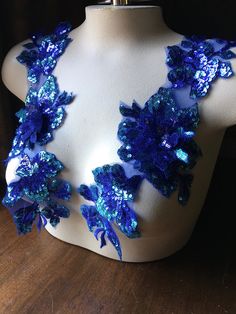 a white mannequin with blue sequins and flowers on it's back