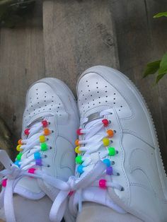 a pair of white sneakers with colorful beads on them