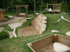 an outdoor play area with wooden structures and grass