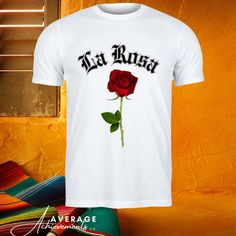 Vintage Rose Tee, La Rosa Shirt, Gothic Rose Top, Old English Style, Elegant Florals, Retro Rose Print, Classic Rose Tee, Floral Script Art, La Rosa Apparel, Romantic Blooms, Vintage Typography, Old World Charm, Rose Garden Wear The unisex heavy cotton tee is the basic staple of any wardrobe. It is the foundation upon which casual fashion grows. All it needs is a personalized design to elevate things to profitability. The specially spun fibers provide a smooth surface for premium printing vividi White Cotton T-shirt With Rose Print, Pink Rose Print Crew Neck T-shirt, White Rose Print Short Sleeve Top, Rose Color Crew Neck Top With Rose Print, Cotton Crew Neck Top With Rose Print, Casual Rose Tops With Rose Design, White Cotton Tops With Rose Print, White Cotton Top With Rose Print, White Cotton Rose Print Top