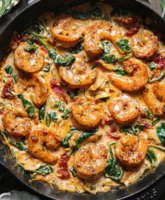 a skillet filled with shrimp and spinach