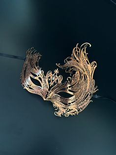 featured is our black metal swan masquerade mask for women. Available in black, rose gold, and gold, each adorned with shimmering crystals, this mask is designed to make you the belle of the ball! Age Group/Gender - Adult/Women Size/Type - One size fits all adults Mask Color - Gold/RoseGold/Black Mask Material - Laser cut metal Gold Venetian Masquerade Mask For Evening, Gold Fantasy Masquerade Mask For Party, Gold Fantasy Style Masquerade Mask For Party, Gold Masks For Evening Carnival, Gold Carnival Masks For Evening, Gold Mask For Mardi Gras Evening, Gold Masks For Mardi Gras Evening Events, Gold Masks For Mardi Gras Evening, Elegant Evening Eye Mask