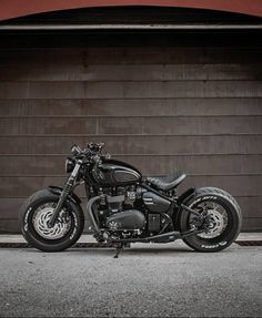 a black motorcycle parked in front of a garage door