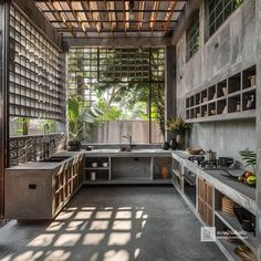 an outdoor kitchen with lots of counter space and open shelves on the wall, along with potted plants