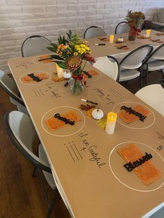 the table is set up with candles and place settings for an autumn themed dinner party