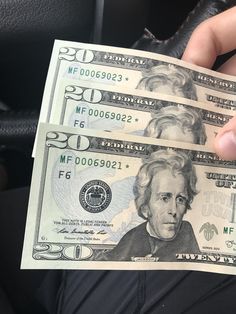 a person holding two bills in their hand