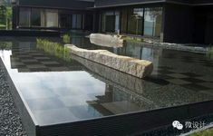 an empty pool in front of a house with large rocks on the ground and grass growing out of it