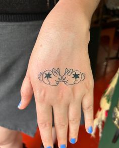 a woman's hand with a small tattoo on it