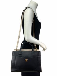 Add this  Chanel Neo Executive Bi-Color Small Shopping Tote 2017 to your collection today! This chic and sophisticated tote has a sleek design and is beautifully crafted from durable black and ivory calfskin with rolled black leather top handles. Featuring a removable, adjustable ivory flat leather shoulder strap, dual exterior pockets and a signature gold-tone 'CC' turn-lock on the front exterior. The top of the bag opens to an interior center dividing zipper compartment and is finely lined in an ivory woven fabric with zipper and patch pockets. Shop  designer handbags by Chanel at Bags Alora. Condition: Excellent. Like-new inside and out. A step under being brand new. Absolutely gorgeous. Includes original dust cover.  Black and ivory two-tone leather  Rolled leather tote straps, 5.5'' d Ivory Flats, Black Leather Top, Leather Roll, Zip Pouch, Exclusive Bag, Shopping Tote, New Bag, Leather Top, Leather Tote