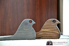 two wooden birds sitting next to each other