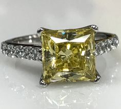 a fancy yellow diamond ring with diamonds around it