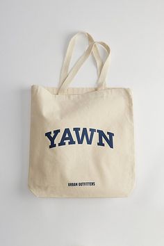 School spirit slogan tote bag by Urban Outfitters. Essential 12 oz. cotton canvas bag with carry handles & topped with a graphic print at the front. Features YAWN tote bag Campus slogan tote bag Front graphic print 12 oz. cotton canvas Classic single pocket Woven carry handles Content + Care 100% Cotton Spot clean Imported Size Dimensions: 15" w x 16" h x 3" d Handle drop: 21" | Urban Outfitters YAWN Tote Bag in Neutral, Men's at Urban Outfitters Casual Streetwear Bags With Logo Print, Casual Cotton Canvas Bag With Screen Print, Casual Tote Bag With Logo Print, Casual Canvas Bag With Screen Print For Everyday Use, Casual Canvas Bag With Screen Print, Casual Canvas Bags With Logo Print, Casual Everyday Canvas Bag With Screen Print, Casual Cotton Bags With Logo Print, Rectangular Canvas Bags For Streetwear