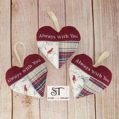 three heart shaped ornaments hanging on a wooden surface with the words always with you written on them