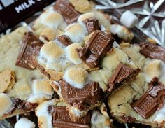 a pile of marshmallows and chocolate on top of a glass plate with foil