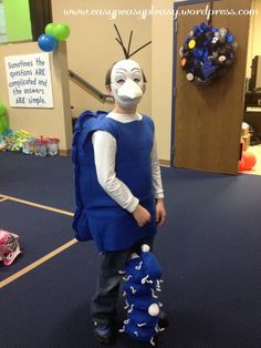 a young boy wearing a costume made to look like a bird with a blue backpack