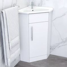 a white bathroom sink sitting next to a towel rack