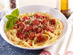 a white bowl filled with spaghetti and meat