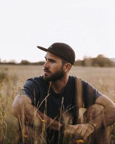 a man sitting in the middle of a field