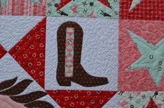 a quilted wall hanging with the letter q on it's center and stars