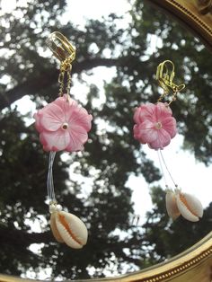 ✧ ೃ༄ Length: ~4.6 in ✧ ೃ༄ Carefully put together with super cute shell carved pink flowers, cowrie shells, tiny pearls, and illusion cord to give the effect of the dangling cowrie shells. ✧ ೃ༄The earring hooks and wire are gold in color. Bohemian Flower Charm Jewelry For Beach, Pink Flower-shaped Jewelry For Vacation, Pink Flower Jewelry For Vacation, Bohemian Summer Jewelry With Flower Decoration, Bohemian Jewelry With Flower Decoration For Summer, Summer Dangle Jewelry With Flower Decoration, Summer Beach Jewelry With Flower Shape, Summer Beach Flower Jewelry, Summer Vacation Jewelry With Flower Shape