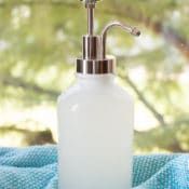 a white soap dispenser sitting on top of a blue towel