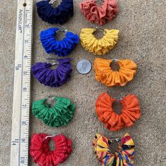 several different types of hair clips next to a measuring ruler on the ground with a coin in front of them