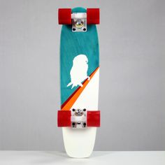 a skateboard with an image of a bird on it's side and red wheels