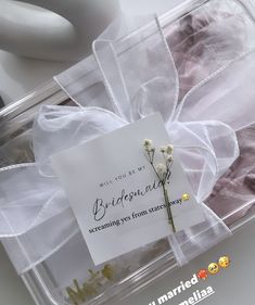 there is a wedding card in a plastic box with flowers on the label and ribbon around it