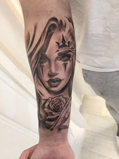 a person with a tattoo on their arm holding a rose and an evil woman's face