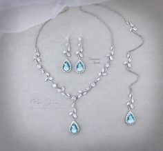 a necklace and earring set with blue topazte, diamonds and white pearls