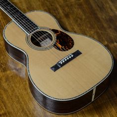 an acoustic guitar sitting on top of a wooden table