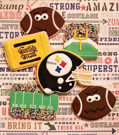 some decorated cookies are laying on top of a paper sheet with footballs and other sports related items