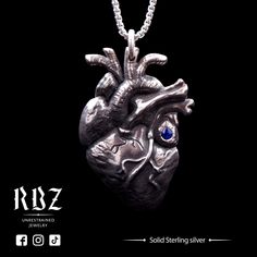 a silver heart pendant with blue eyes on a black background