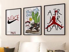 three framed art pieces hang on the wall above a white couch in a living room