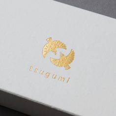 a white box with gold foil on the lid that says tsugumii in it