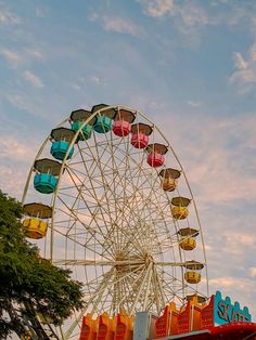 the ferris wheel is brightly colored and has many seats for people to sit on it