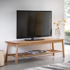 a flat screen tv sitting on top of a wooden stand