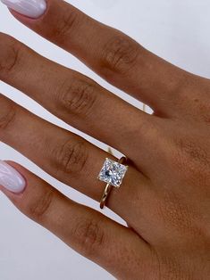 a woman's hand with a ring on it and a diamond in the middle